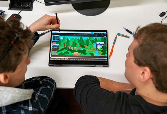 图为两名学生正在制作描绘游戏设计的平板电脑.